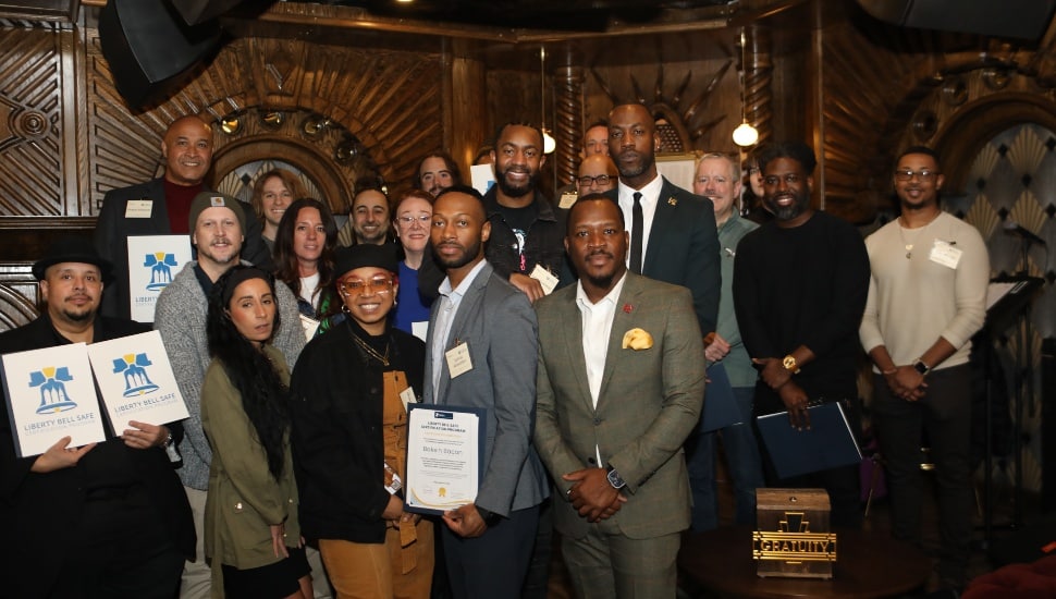 A group of business owners hold up their Liberty Bell Safe Certificates.