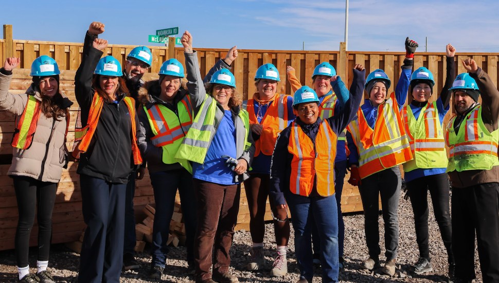 A gathering of happy workers wearing hard hats.