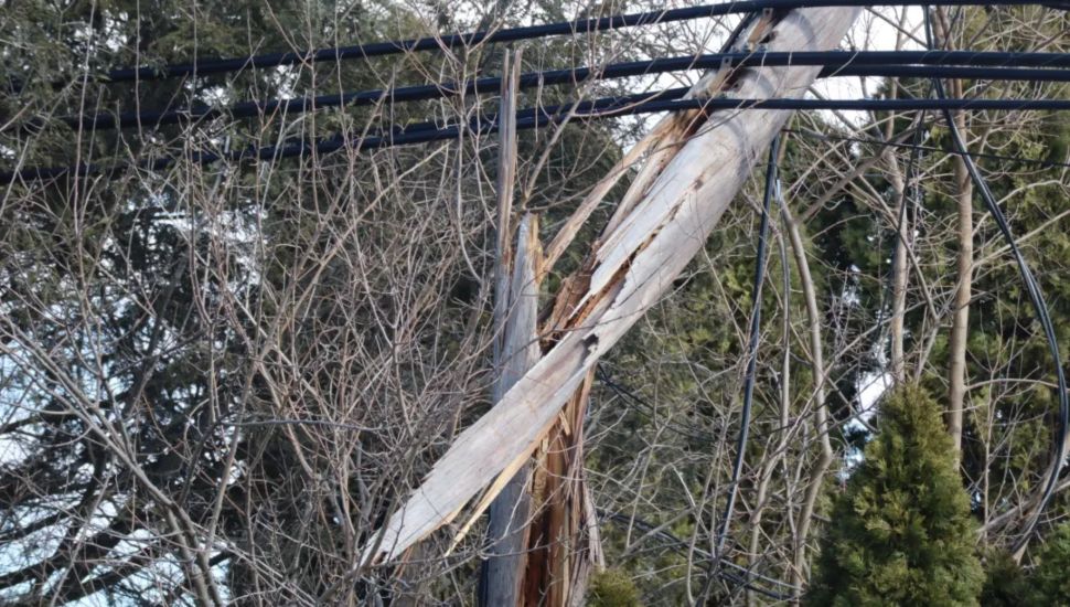 A telephone pole is damaged from high winds Sunday.