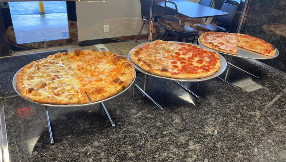 Three different pizzas on display at A & G Pizzeria Locale.