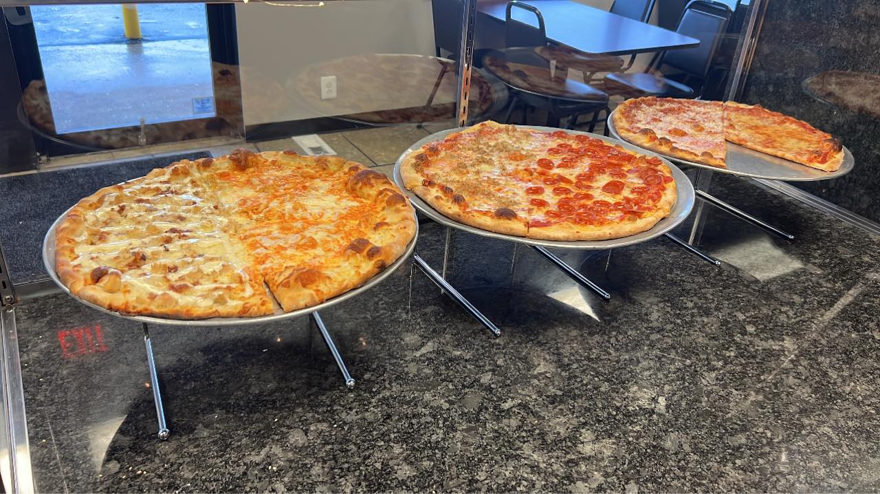 Three different pizzas on display at A & G Pizzeria Locale.