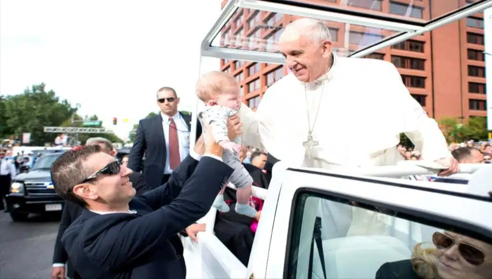 A security agent hands Matt Campuzano over to Pope Francis during his travels around Philadelphia in 2015.