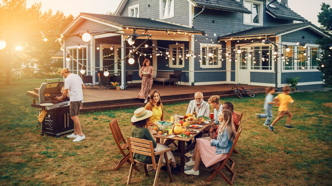 Family and friends celebrate at an outdoor barbecue.