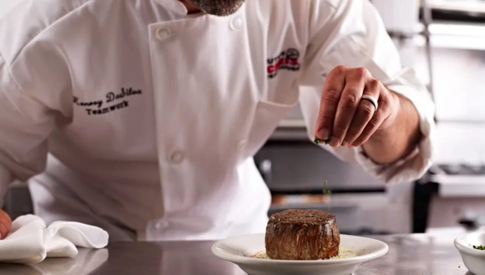 A chef prepares a filet at Ruth's Chris Steakhouse.