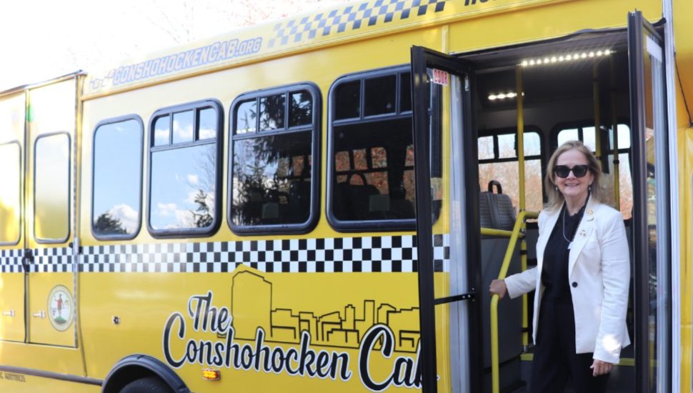 A woman stands at the doorway into a Conshy Cab.