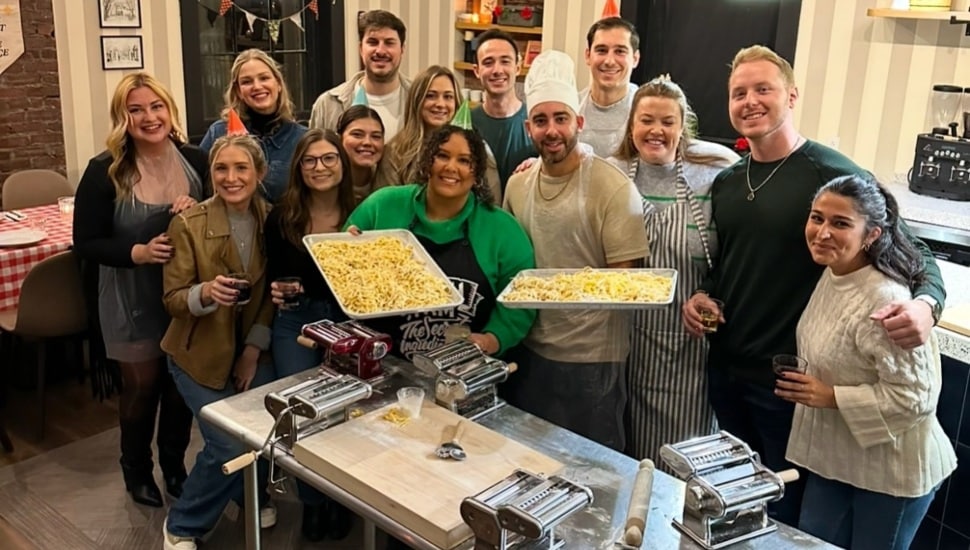 the staff of Midnight Pasta holds up trays of pasta.