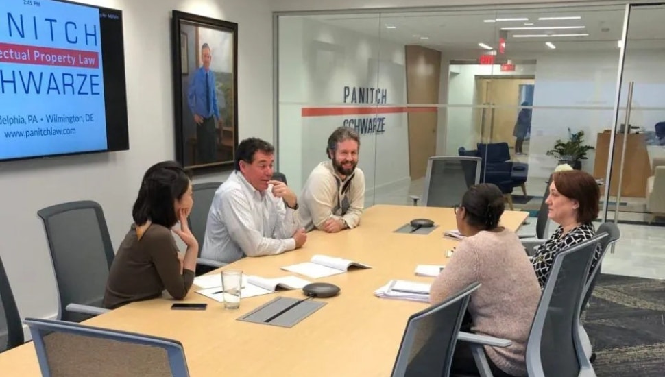 Lawyers talk around conference room table.
