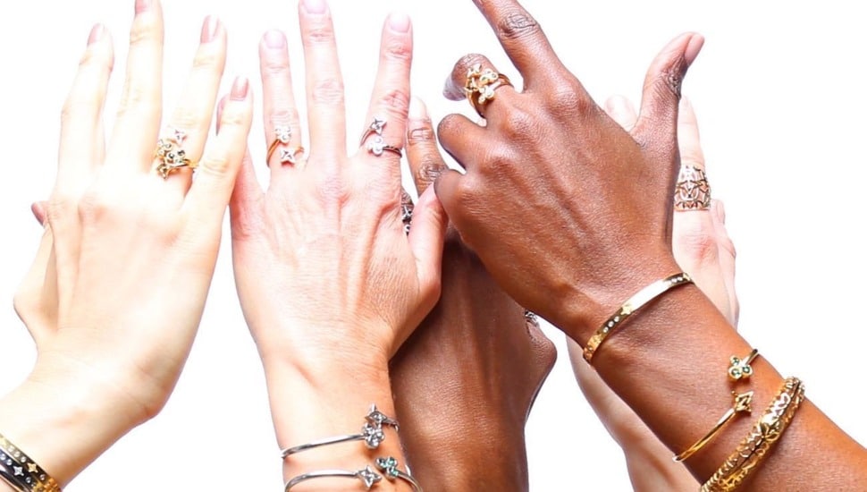 Two pairs of hands showing off some rings.
