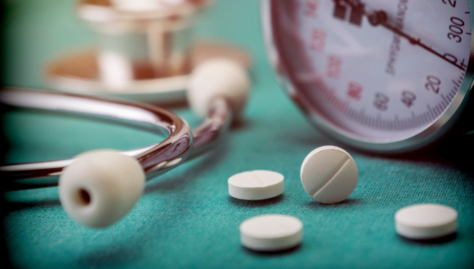 A table with pills, a blood pressure monitor and a stethoscope.