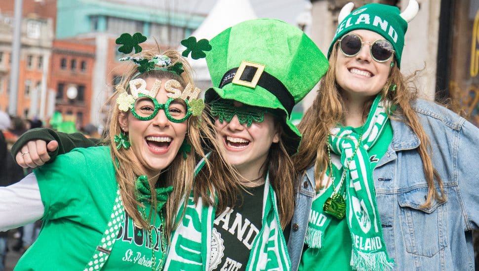 Three young women wearing St. Patrick's Day outfits are caught up in the spirit of Glenside's first St. Patrick's Day parade.
