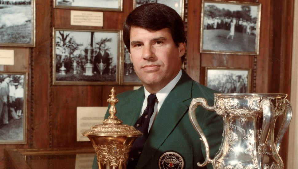 Hall of Fame Golfer Jay Sigel surrounded by trophies and wall photographs.