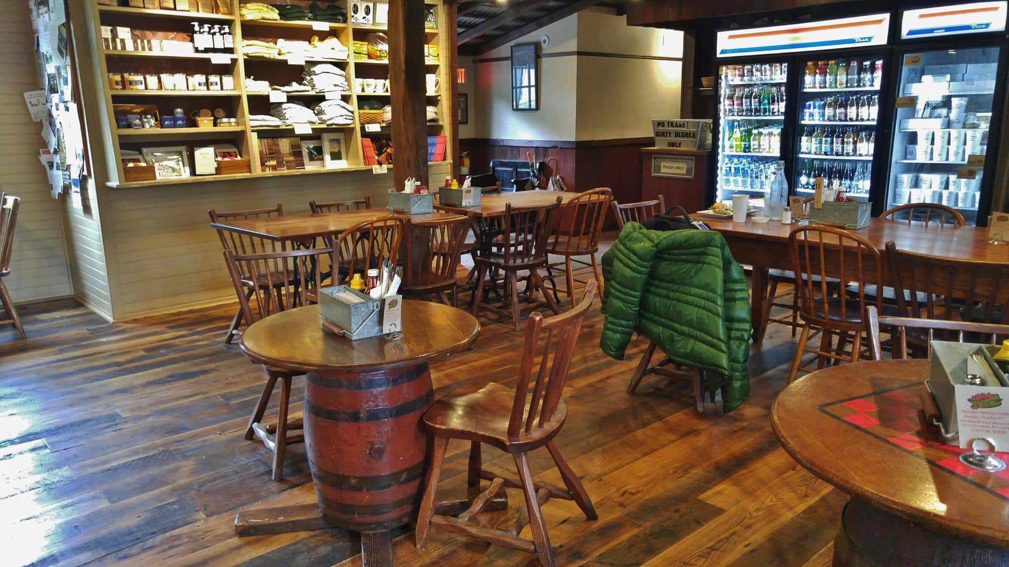 An inside look at Lumberville General Store with wooden floors, barrel tables and chairs and an old-fashioned counter.