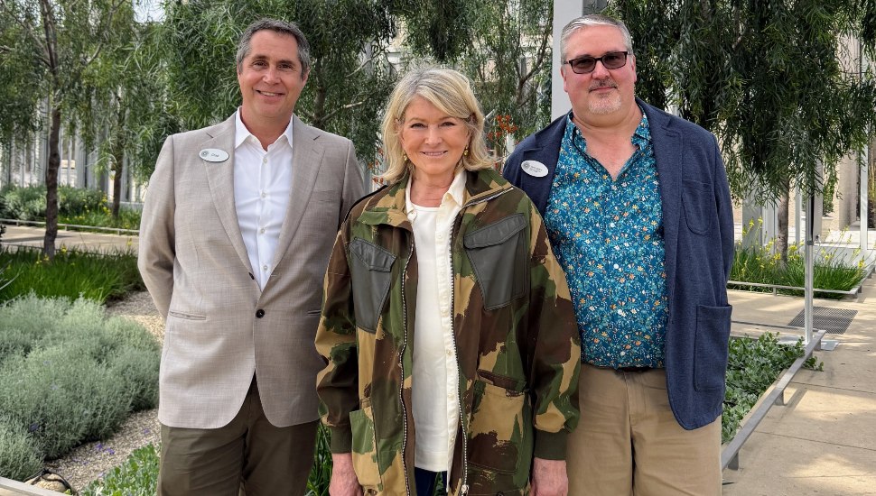 Martha Stewart stands with two gentleman on a path at Longwood Gardens.