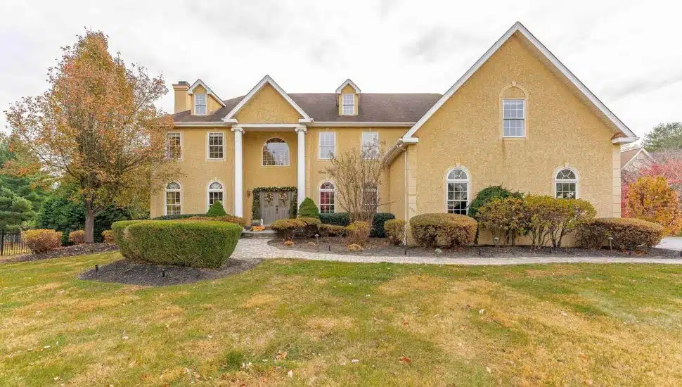 A contemporary home at 528 Old Forge Road in Media with a front lawn, trees, and shrubbery.