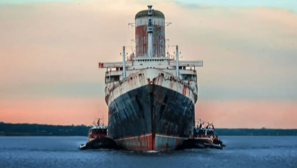 The SS United States underway heading towards the camera during sunset.