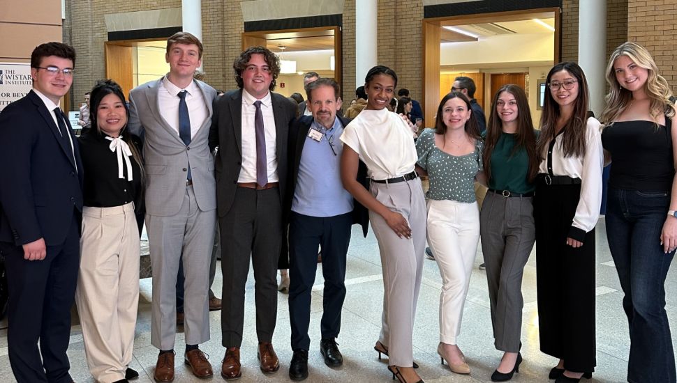 WCU students and WCU’s Cottrell Center’s Entrepreneur-in-Residence Marc Duey at Wistar Institute's Life Science Innovation Shark Tank competition. The student are gathered in a line with arms around each other. They are dressed in professional attire.