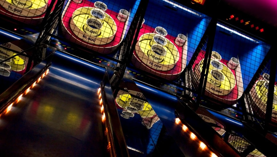 A distorted look at a row of Skee Ball aisles with the camera tilted.