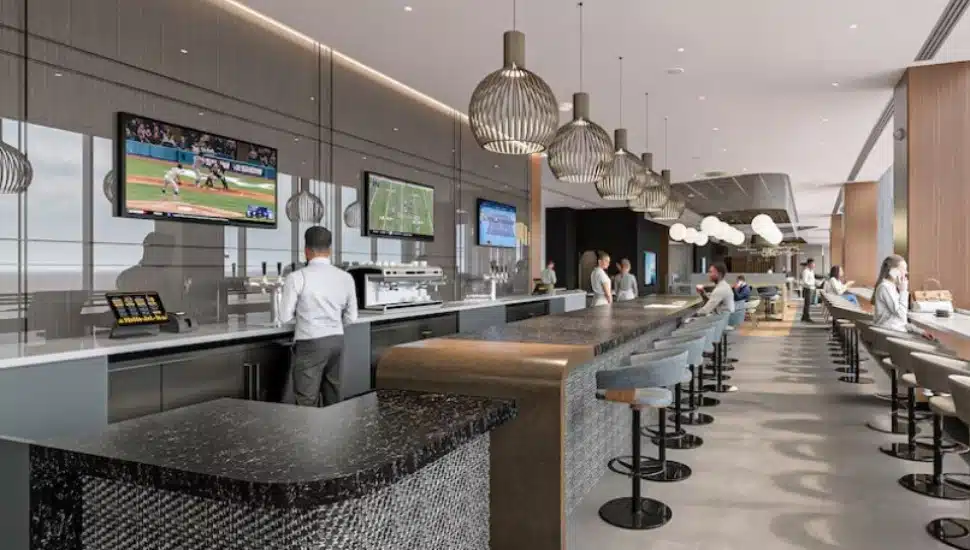 A counter and stools and tables, with a cook behind the counter, a rendering depicting the look of American Airline's new Flagship Lounge at the Philadelphia International Airport.