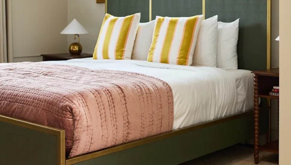 A bed and lamp in a hotel room.