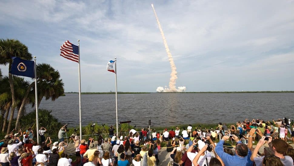 A plume of smoke from the Celestis rocket launch as spectators look on.