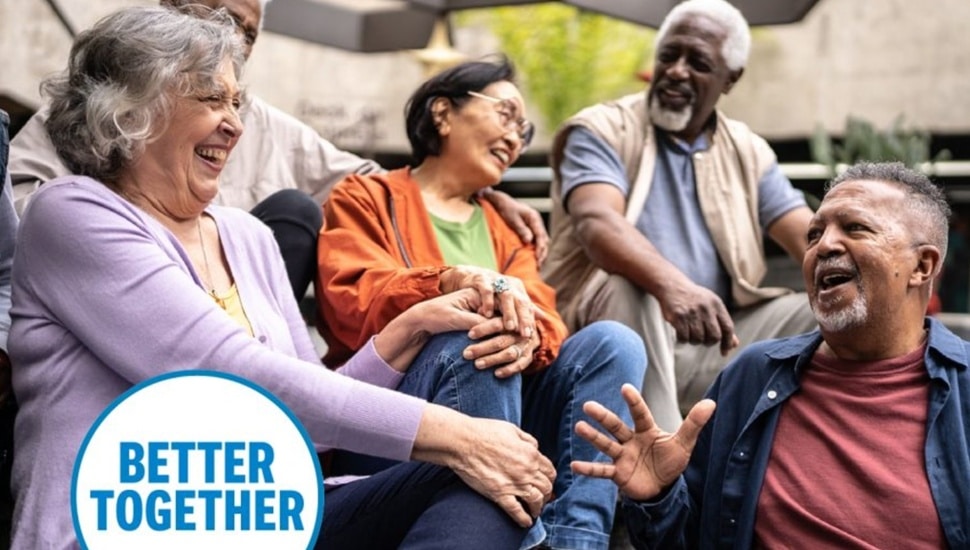 Group of senior citizens smile and laugh together.