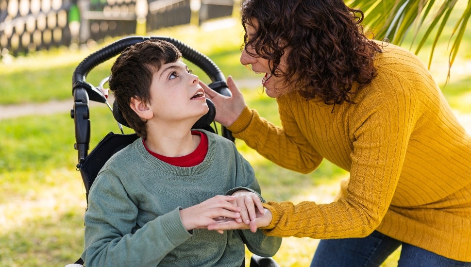 A mother helps her son, who has a disabiilty.