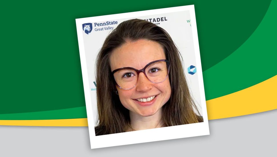 Headshot of Kirby against WilmU's green and yellow colors. She has long brown hair and wears glasses, and is smiling.