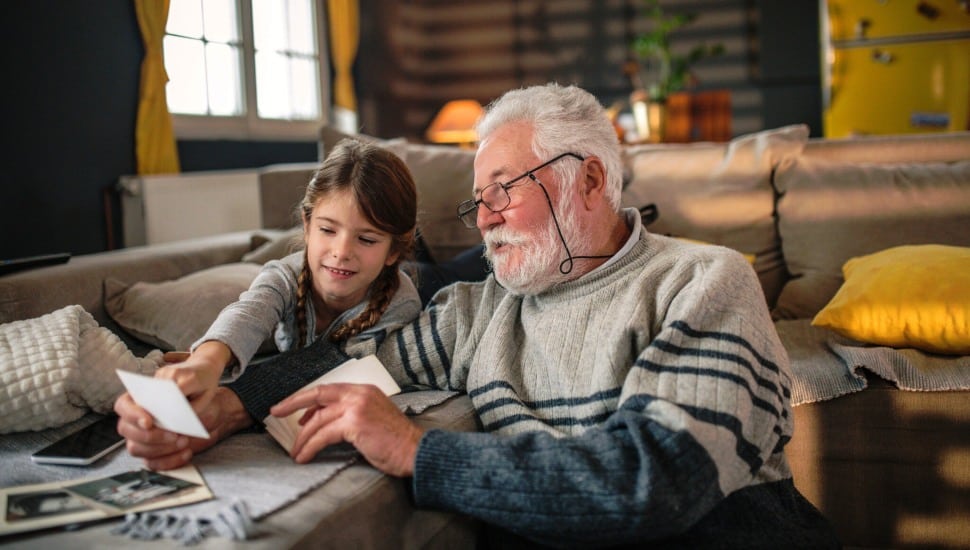 Grandad showing his granddaughter memories from the past.
