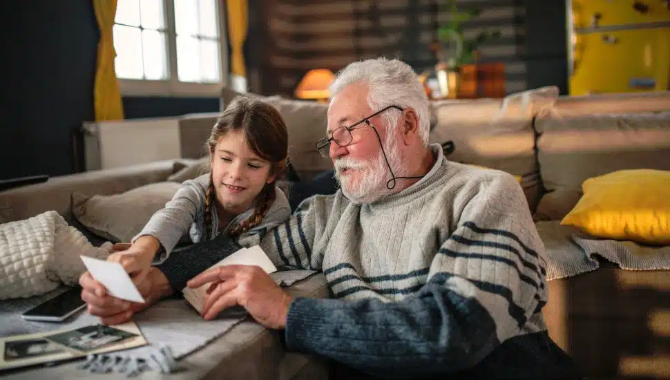 Grandad showing his granddaughter memories from the past.