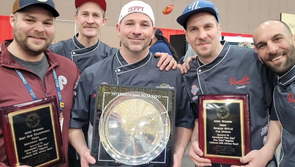 Five staff members of Mezzaluna Wood Fired Pizza gather and show off their awards.