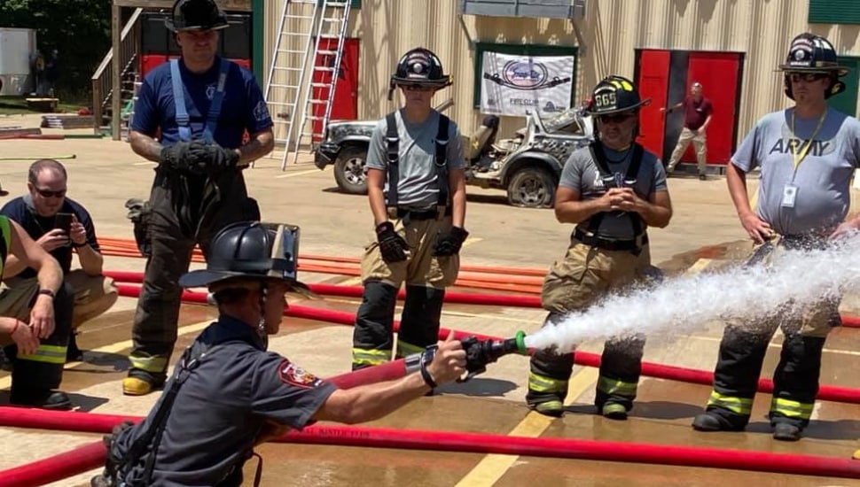 Firemen using fire hoses.