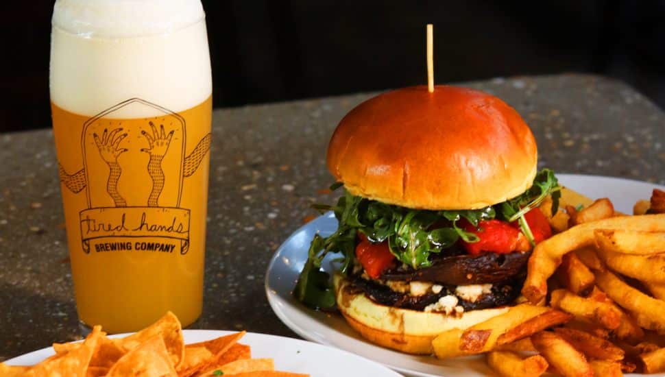 A burger, fries and a tall glass of beer at Tired Hands Brewing.
