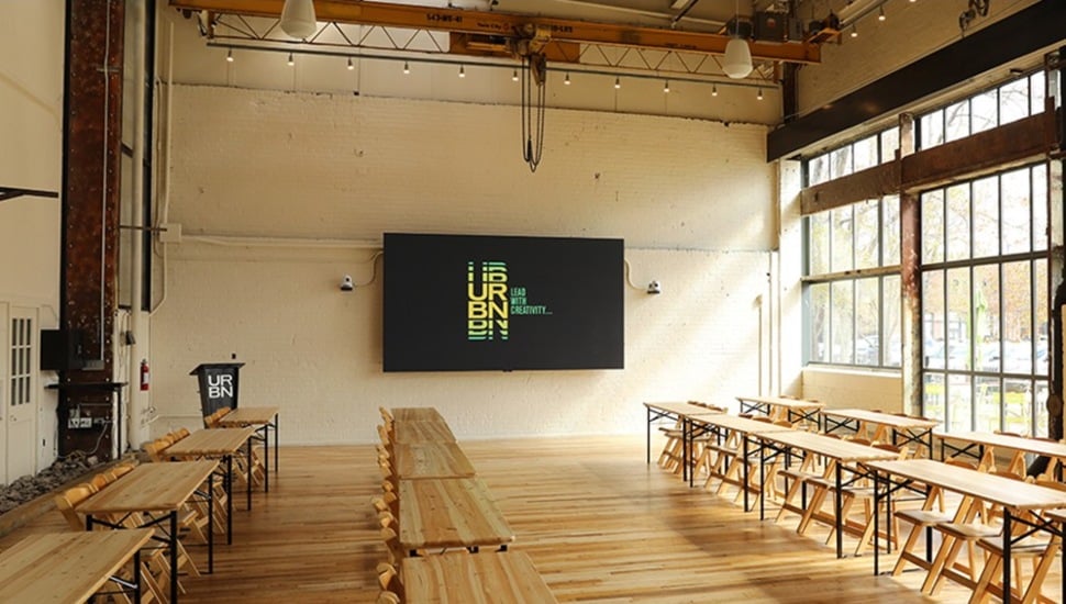 Lecture hall in industrial setting with mounted television.