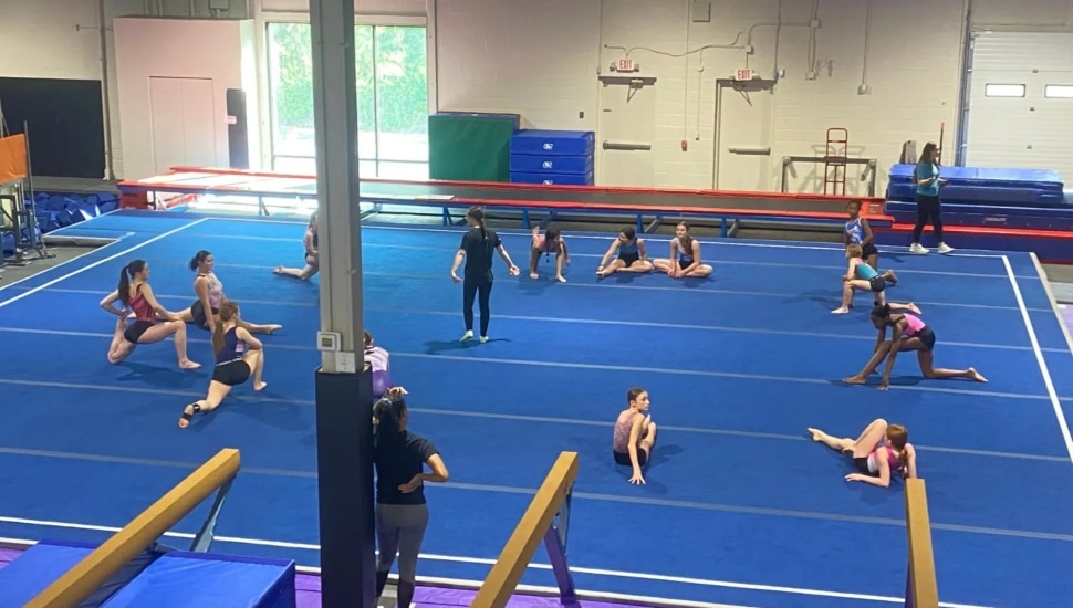 Several young gymnists practice floor routines at a new gymnastics center.