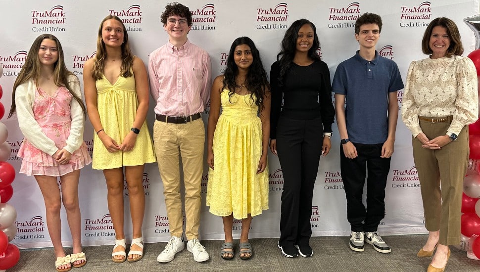 High school students receive scholarship from credit union CEO.