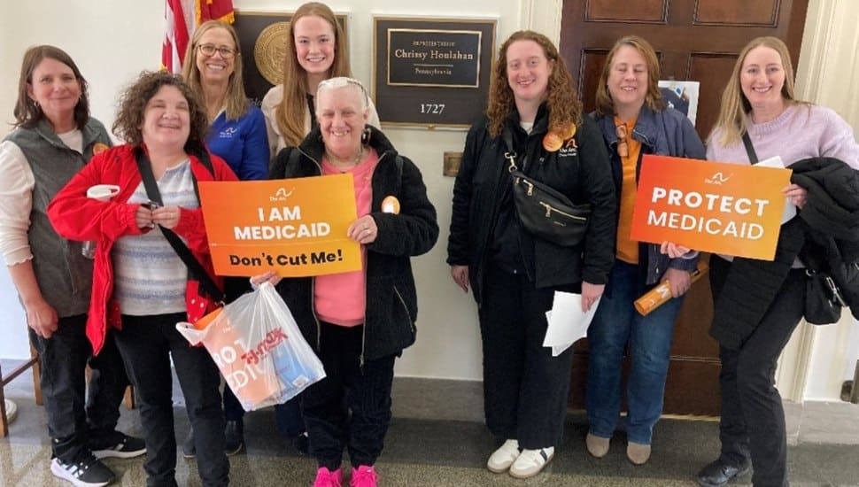 Arc advocates and self-advocates meeting with staff for Rep. Chrissy Hoolahan, holding signs.