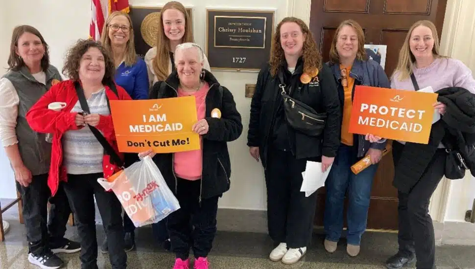 Arc advocates and self-advocates meeting with staff for Rep. Chrissy Hoolahan, holding signs.