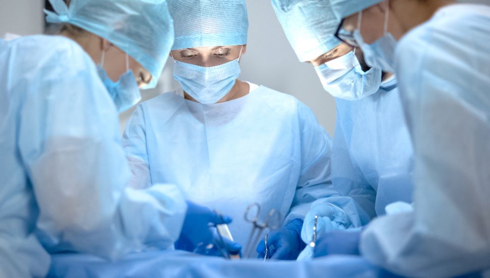 Surgeons perform surgery on a patient in the operating room.