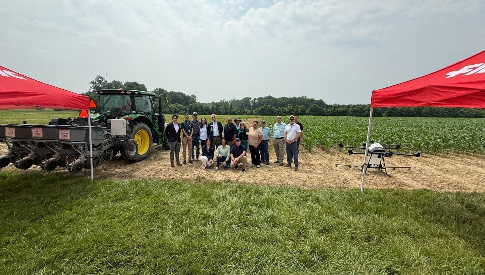 A group from the FMC Corporation standing in a field.