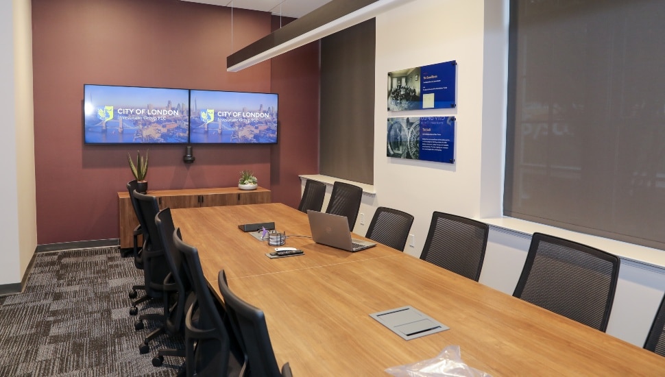 Empty conference room with tables, chairs, and monitors.