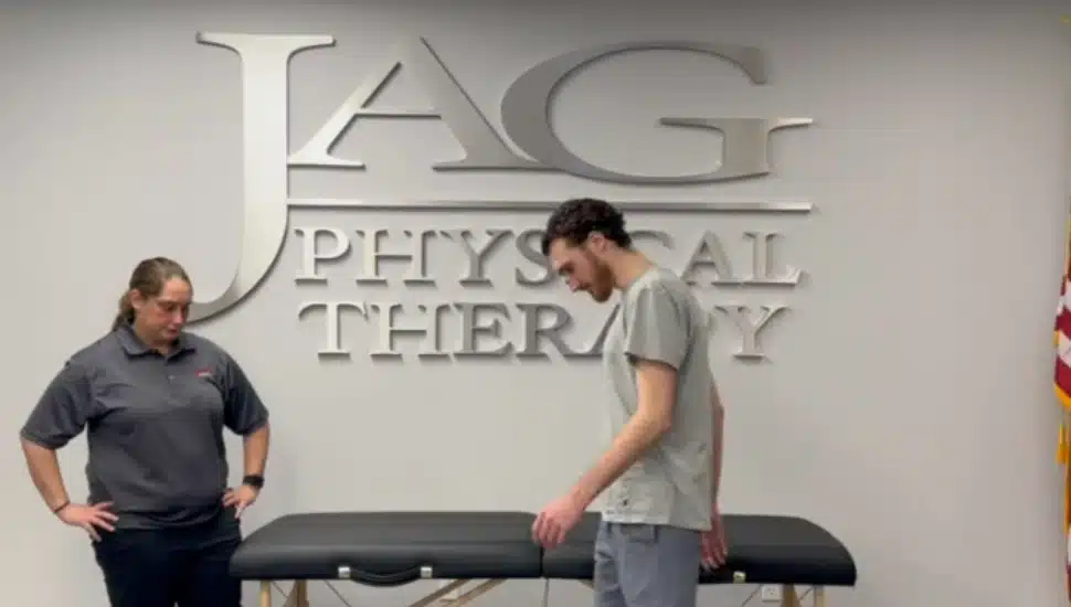 Two physical therapists in front of a therapy table at JAG Physical Therapy.