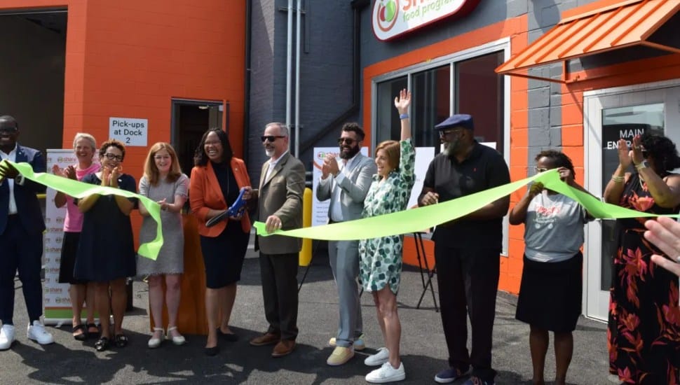 Dr. Monica Taylor, Delaware County Council chair, cuts the ribbon held by Marc Lucca, president of Aqua Pennsylvania, at the new Share Food Program warehouse in Holmes.