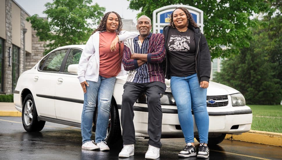 Shellman Washington III with his two daughters Davay and Da'Veigh Washington standing with their Chevrolet Impala.