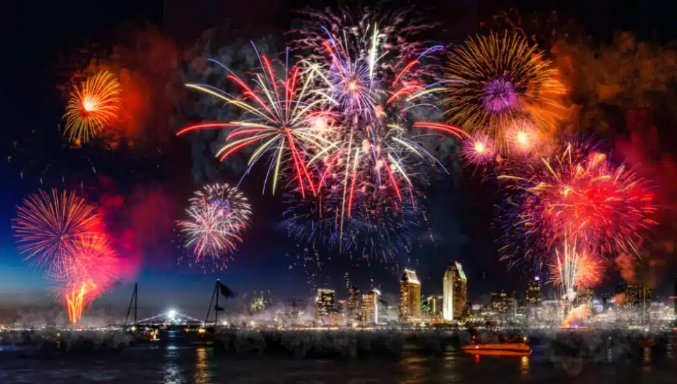 A blaze of different fireworks in the sky over a city.