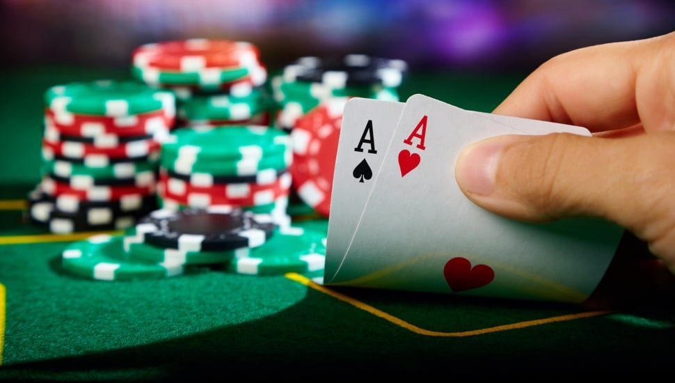 Two aces in a poker hand with chips on the table.