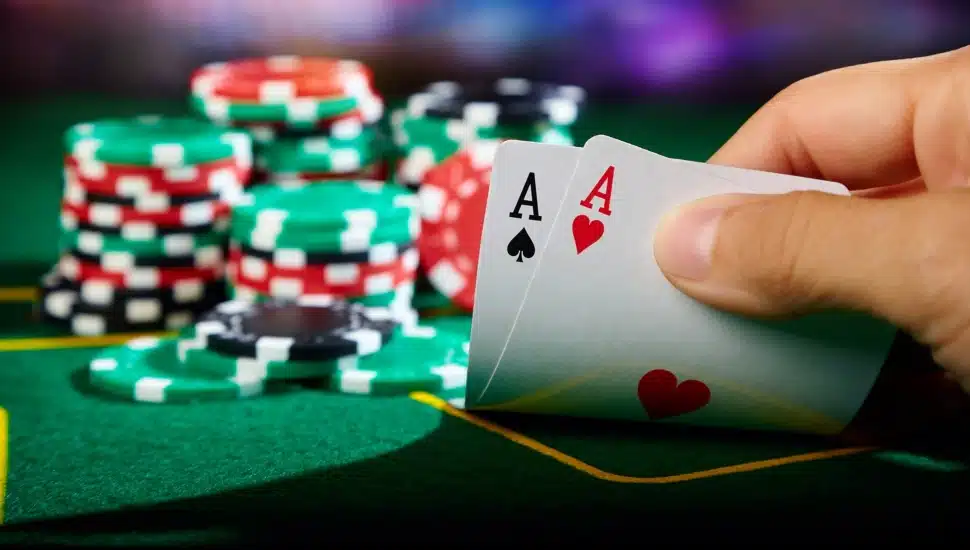 Two aces in a poker hand with chips on the table.