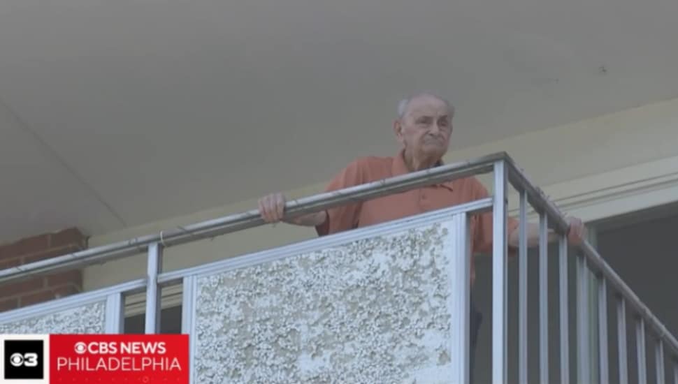 A resident of Newtown Towers looks out from his balcony during a multi-day power outage that left the senior residents without air conditioning, refrigeration or elevators.