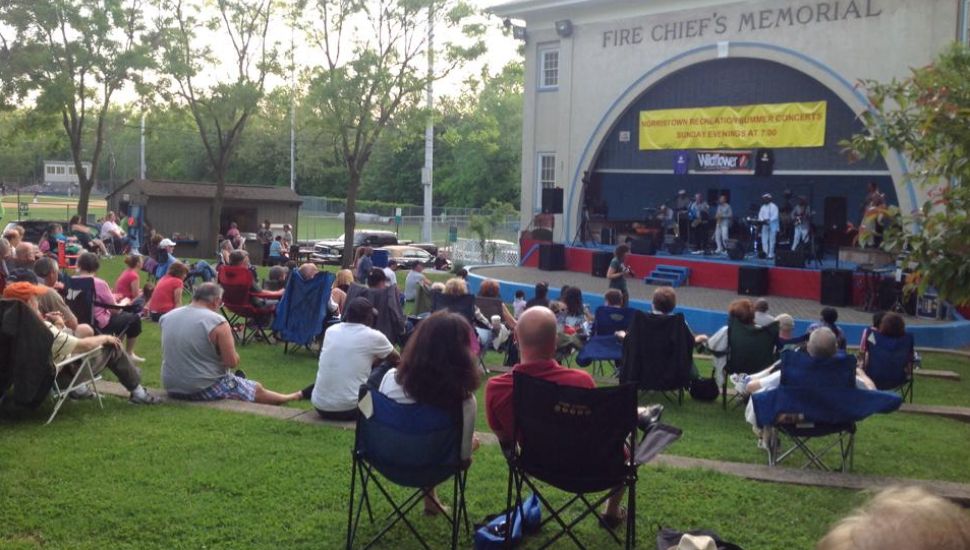 Spectators sit on the grass during an outdoor show at Elmwood Park.