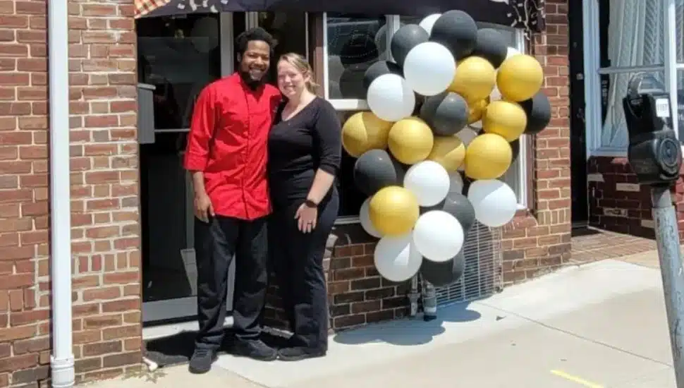 Marcus and Jessa Hyman stand in front of their new take-out restaurant, Drexel Hill Sauté, ready with balloons for the grand opening.