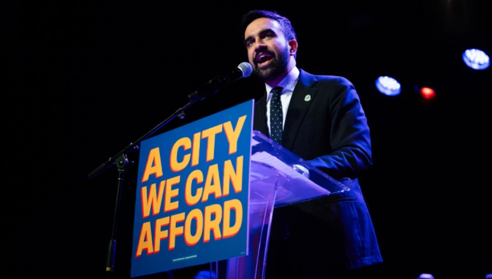 New York City mayoral candidate Zohran Mamdani addressing a crowd from a podium.